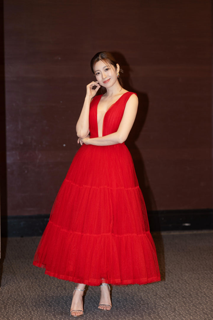 Woman artist  in a red dress posing 